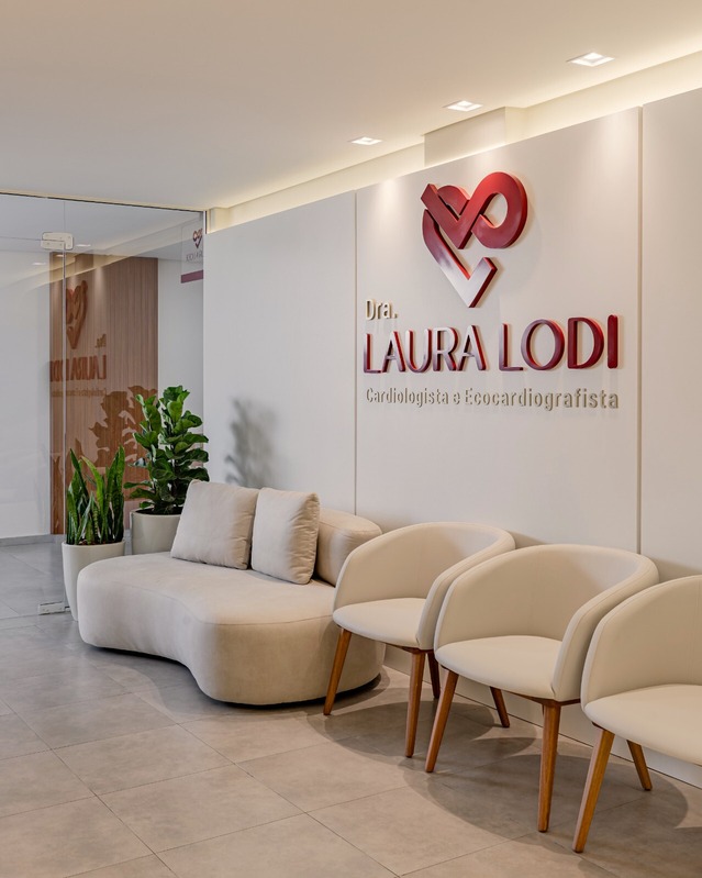 Sala de espera da clínica com poltronas e balcão de recepção